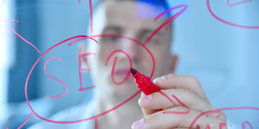 Trade worker writing SEO diagram on transparent screen. Web technology and search marketing concept